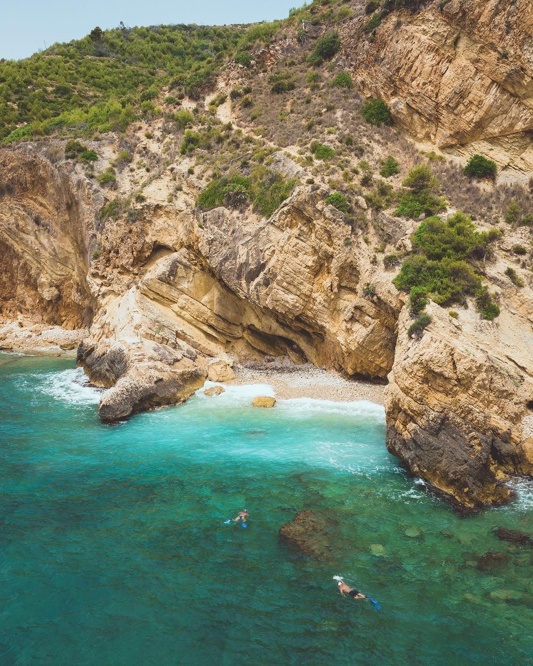 Cala escondida de roca y agua transparente en Jávea